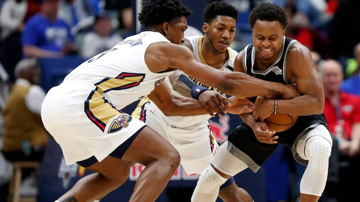 New Orleans Pelicans forward Stanley Johnson, left, and guard Elfrid Payton, center, reach for the ball against Sacramento Kings guard Yogi Ferrell, right, during the second half in New Orleans, Thursday, March 28, 2019.