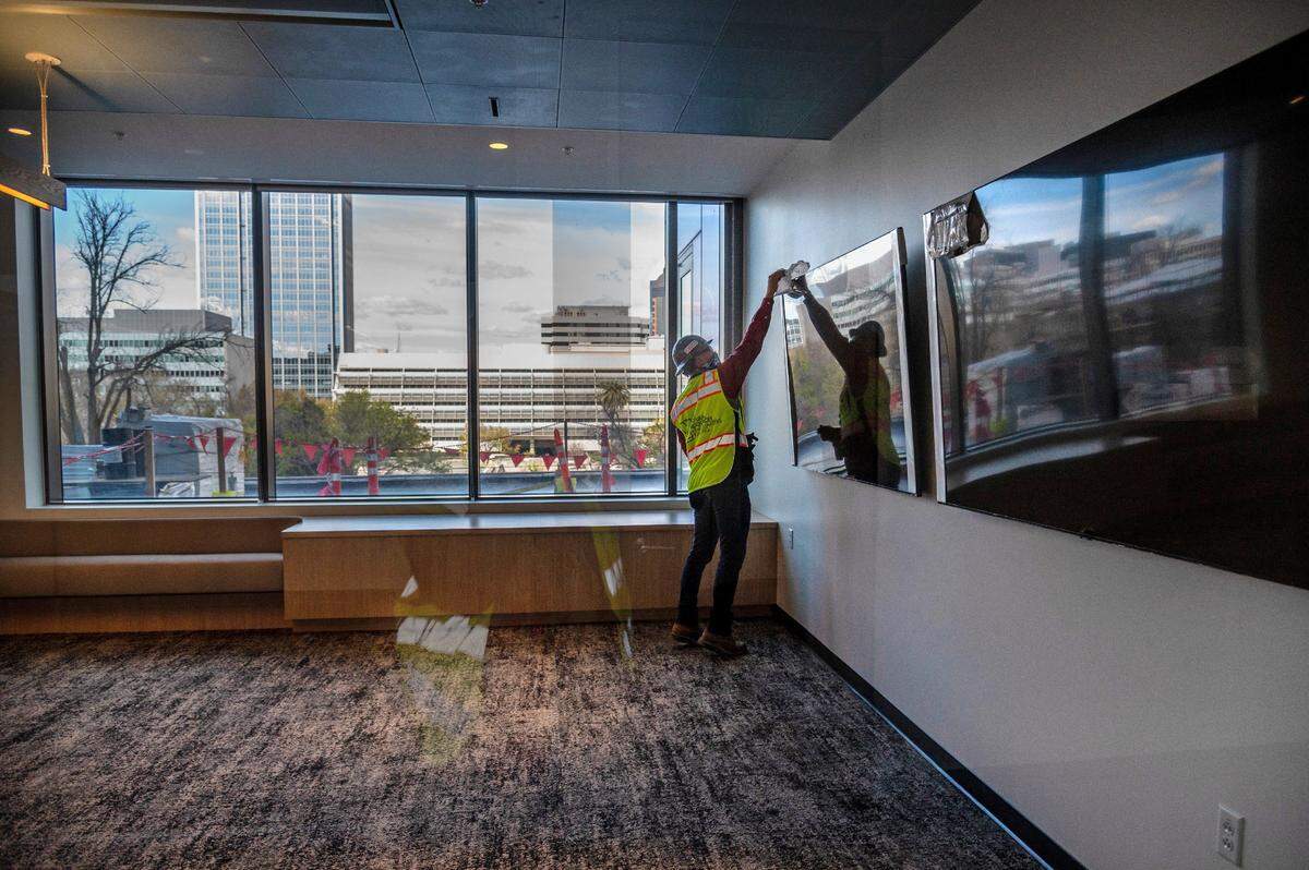 Erik Heerhartz, project director with the state Department of General Services, removes plastic from a video monitor in a large conference room on the third floor of the Natural Resources Headquarters building in downtown Sacramento on Thursday.