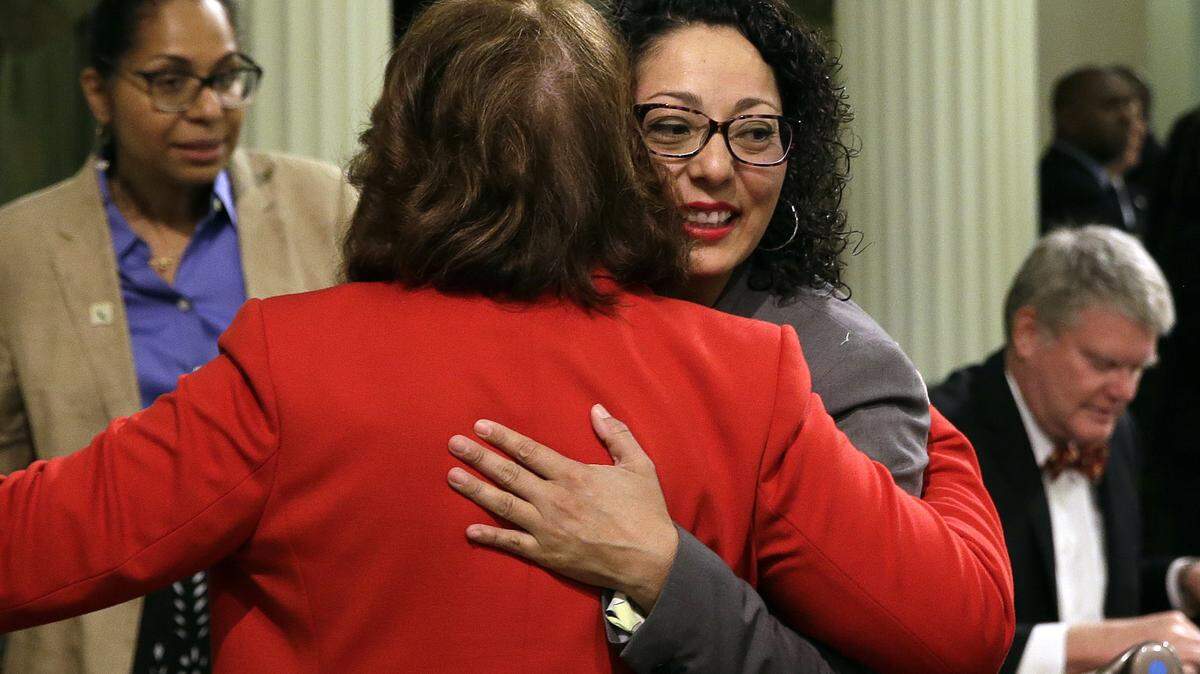 Assemblywoman Cristina Garcia, right, D-Bell Gardens, is hugged by Assemblywoman Eloise Gomez Reyes, D-Grand Terrace, on her first day back in the Assembly since an investigation into sexual misconduct charges on May 25, 2018.