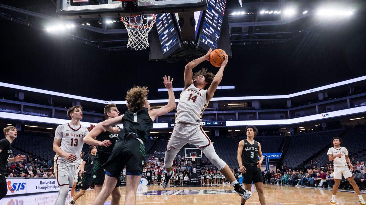 Whitney Wildcats guard Elijah Samdahl (14) goes up for a shot as the Granite Bay Grizzlies’ Brayden Honebein (1) defends during the fourth quarter of the CIF Sac-Joaquin Section Division II high school boys basketball final game Friday, Feb. 24, 2023, at Golden 1 Center in Sacramento.