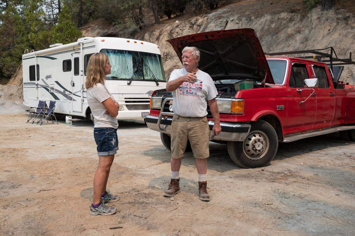 Robert Troyer, right, speaks with Tina Rossi, the owner of Saluti Cellars in Somerset where he parked his RV after evacuating during the Caldor Fire on Wednesday, Aug. 18, 2021. Troyer and his wife later found out that they lost their home in Grizzly Flats to the fire.