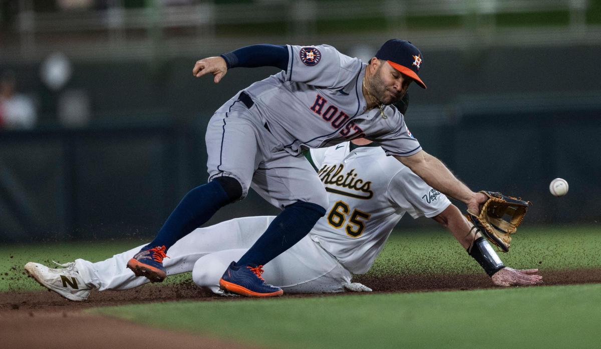 Athletics catcher Willie MacIver (65) slides safe on to second base as Houston Astros second baseman Jose Altuve (27) misses a throw from the catcher during a baseball game at Sutter Health Park on Monday.