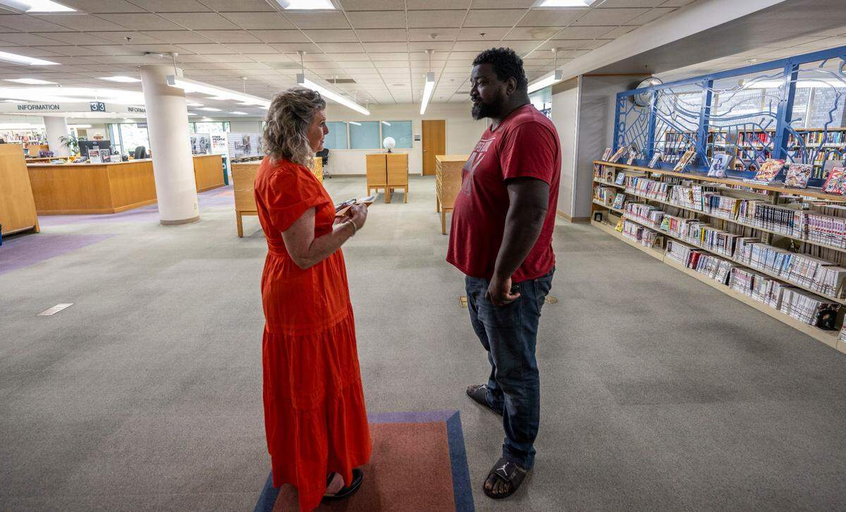 Maria Montano, a social worker at the Sacramento Public Library, talks with Darnell Diggs, who she is helping with a job search, last month.