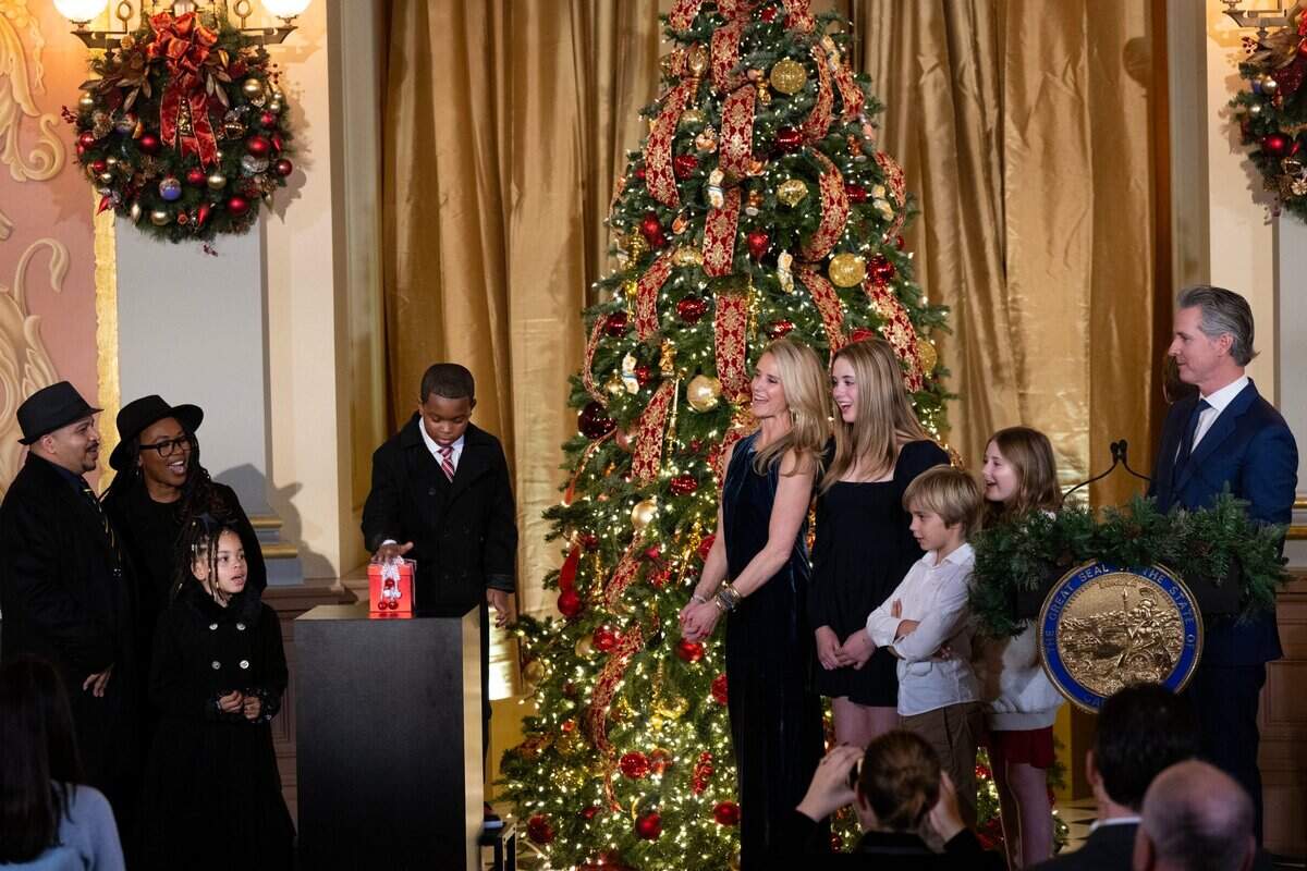 Carter Morris, 9, from Merced pushes the button to light the California Capitol tree with Gov. Gavin Newsom and First Partner Jennifer Siebel Newsom and their children during a ceremony at the state Capitol in Sacramento on Wednesday, Dec. 11, 2024. Carter, joined at left by parents Lynne and Karl Morris and sister Samira, was selected by the Central Valley Regional Center to light the tree and represent the more than 450,000 Californians with intellectual and developmental disabilities who receive services through the California Department of Developmental Services.