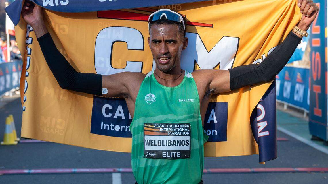 Tsegay Weldlibanos, of Eritrea, holds the champion flag after finishing with a men’s course record of 2:07:35 to win his first-ever California International Marathon on Sunday.