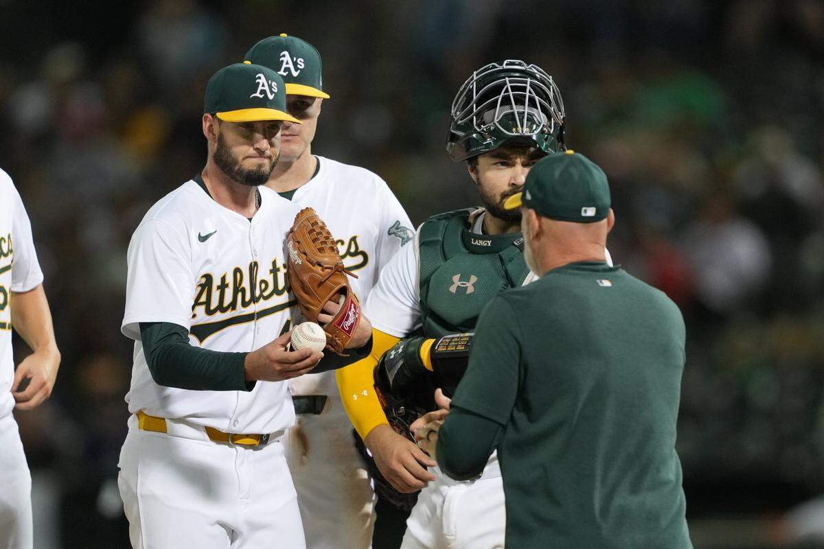 Sep 6, 2024; Oakland, California, USA; Oakland Athletics starting pitcher Mitch Spence (left) hands the game ball to manager Mark Kotsay (right) during the fifth inning against the Detroit Tigers at Oakland-Alameda County Coliseum. Mandatory Credit: Darren Yamashita-Imagn Images