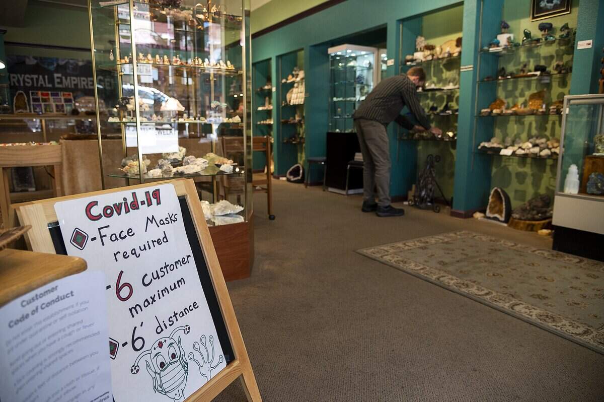 James Hill, owner of Crystal Empire Gems, waits for customers on Monday, May 18, 2020 in Grass Valley during the coronavirus pandemic. A sign in his shop informs customers that face masks are required.