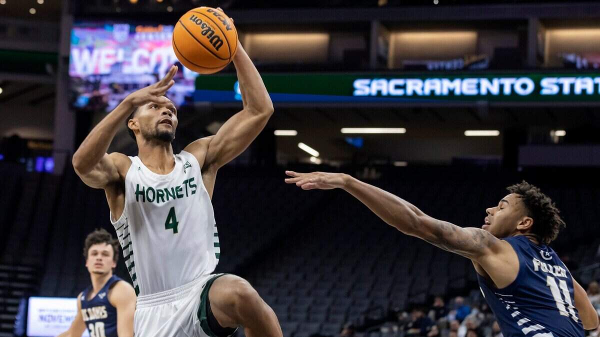Sacramento State Hornets guard Zach Chappell (4) drives past UC Davis Aggies guard Caleb Fuller (11) to dunk the ball during the second half on Tuesday, Nov. 23, 2021 during a nonconference basketball game at the Golden 1 Center in Sacramento. Chappell had 13 points. The Hornets won 75-63.