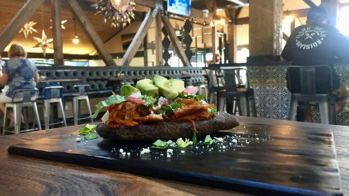 Dos Tlacoyos — two thick masa tortillas made with organic blue corn, stuffed with black beans and topped with meat, lettuce, pickled onion, cotija cheese and avocado — go for $7.95 on Maya Restaurant’s dinner menu.