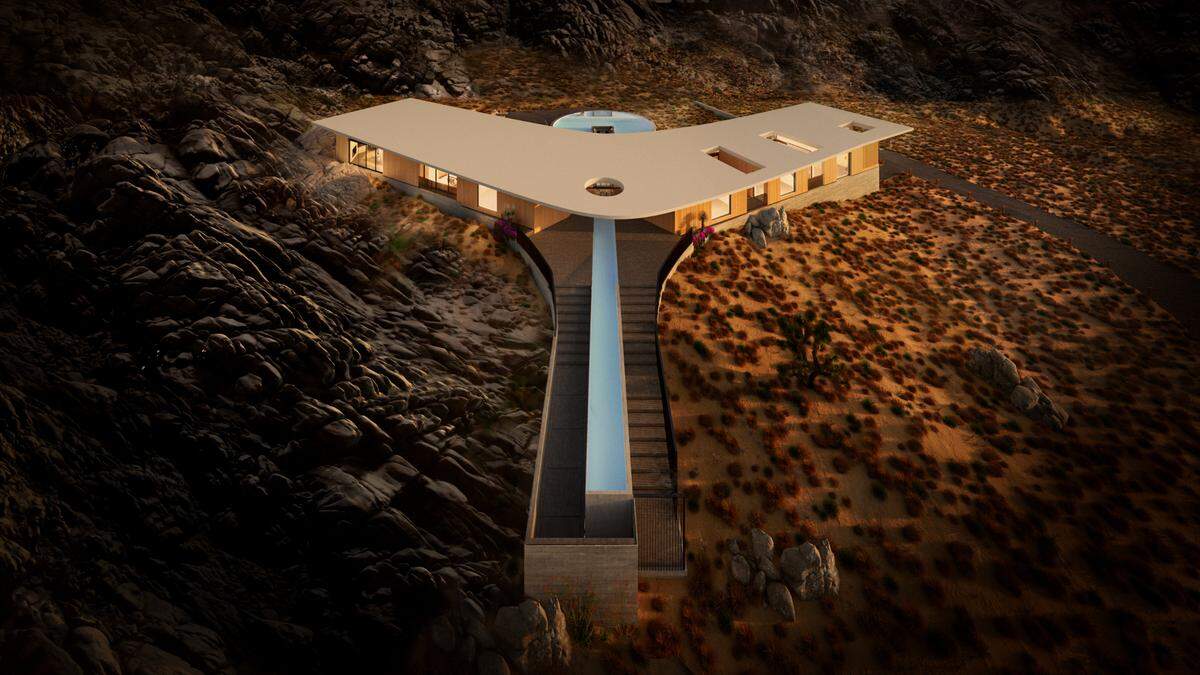 A long reflecting pond is part of the futuristic architecture blending into a rocky desert backdrop.