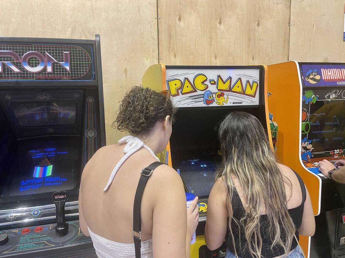 Brie Ceja plays Pac-Man while her friend, Dani Love, watches. Both women competed in the Arcade Game Gauntlet at the California State Fair on Monday.