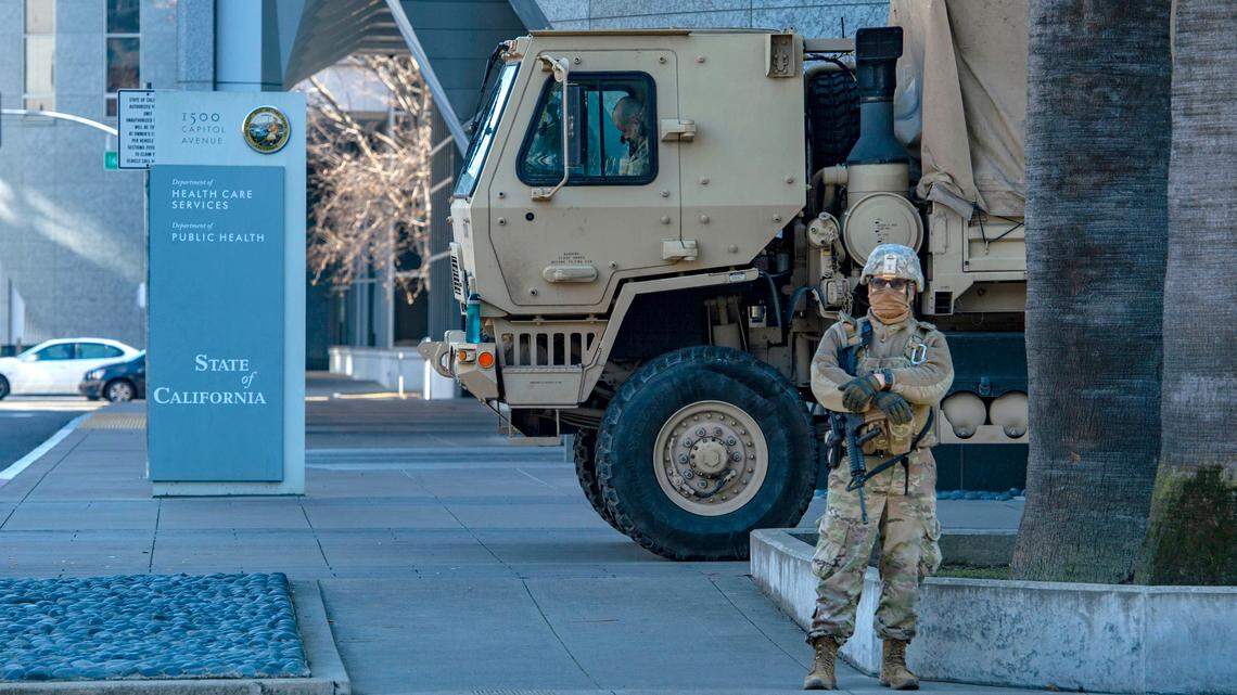 A member of the California National Guard keeps watch in front of the California Department of Public Health near the state Capitol on Sunday, Jan. 17, 2021, in downtown Sacramento. All 50 state capitols are on high alert after warnings of possible violent protests following the riot at the U.S. Capitol.