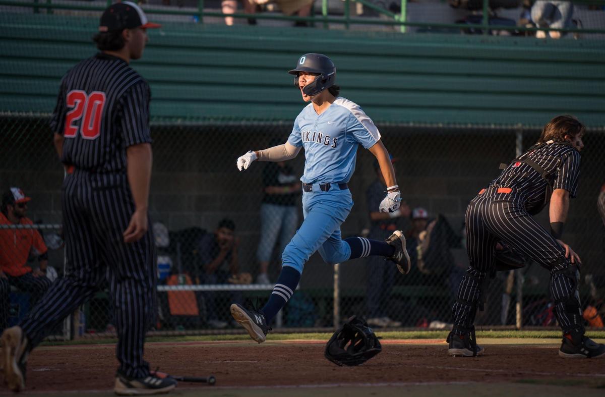 Oakmont Vikings baserunner Ayden Dringenberg (12) yells while crossing the plate to score the third run on a double by KC Tibbits (4) during the third inning of the CIF Sac-Joaquin Section Division IV high school baseball championship game Wednesday, May 24, 2023, at Sacramento City College. Woodland Wolves pitcher Austin Stapleton (20), left, backs up catcher Carter Imbach (1).