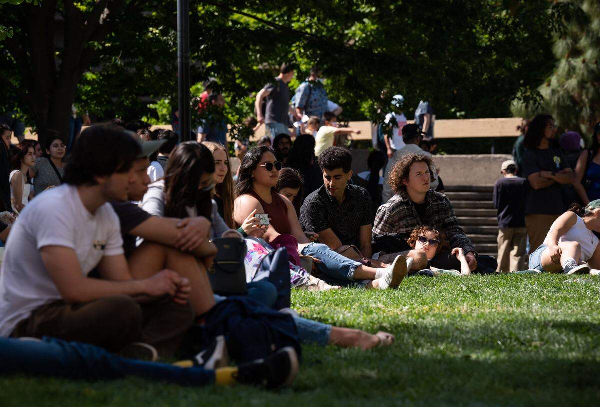 Lola Rose, right, rests her head on her boyfriend, Jonathan Moreci, while listening to music during UC Davis 108th Picnic Day on Saturday, April 23, 2022. Moreci traveled from San Francisco to attend with Rose, who was visiting the campus for the first time after being admitted as a transfer student. Its amazing I really love it, she said.