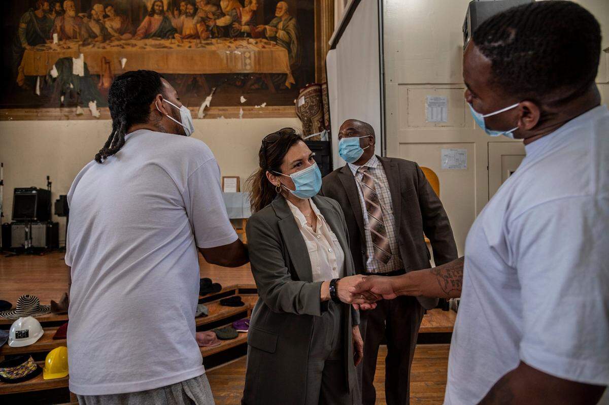 Norma Cumpian greets incarcerated people as she watches a program that was in session inside Folsom Prison’s Greystone Chapel in April. Above them is a peeling mural – a prison version of the Last Supper –painted by inmate Ralph Pecor in 1938.