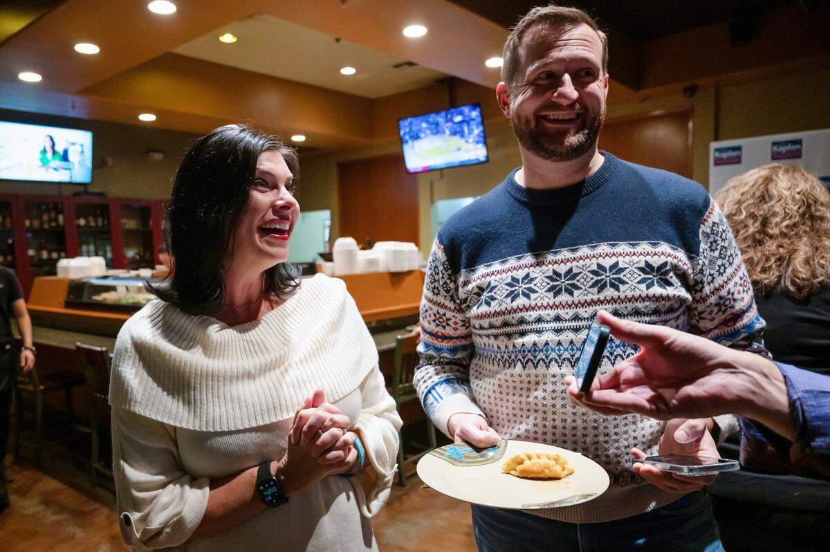 Sacramento City Council candidate Lisa Kaplan and former councilman Steve Hansen look to B.G. Heiland, Kaplan’s husband, as he shows his phone displaying the early returns at an election night party at Oshima Sushi in Natomas on Tuesday, Nov. 8, 2022.