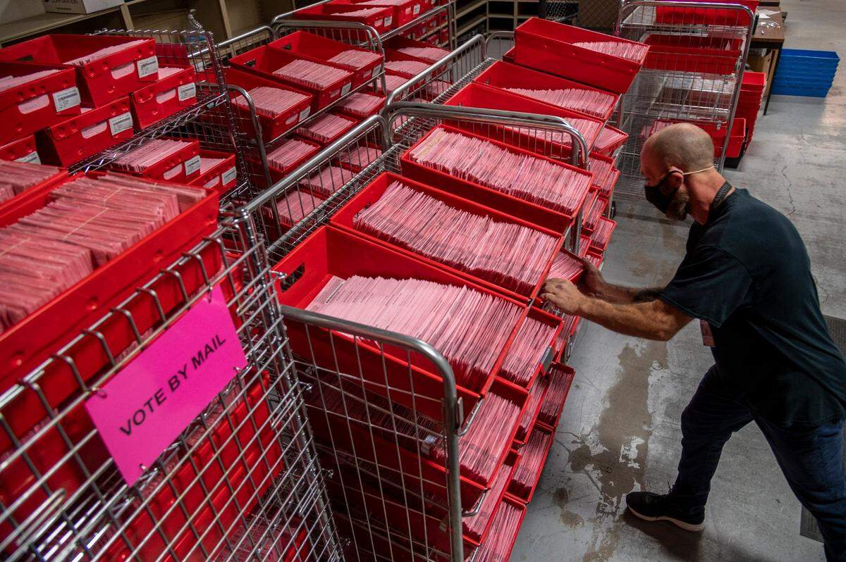 Election assistant David Quiel sorts vote-by-mail ballots at the Sacramento County Voter Registration and Elections Office in November 2020.