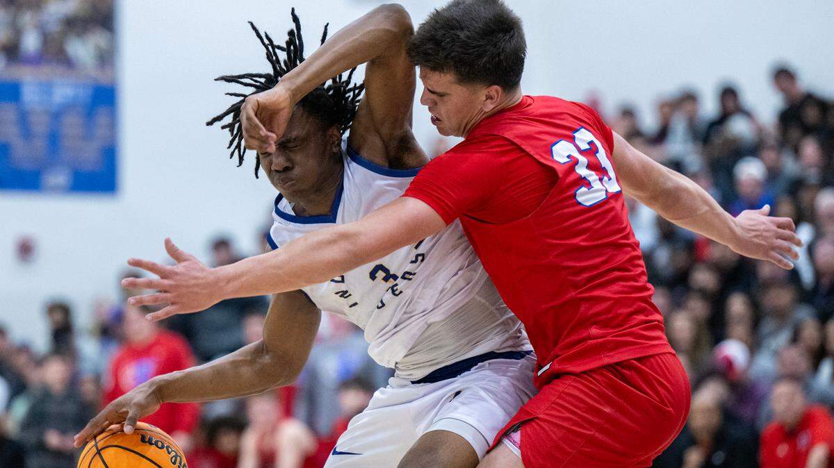 The Folsom Bulldogs’ Ryder Lyons (33) defends the Inderkum Tigers’ Siincere Hudson (3) in the second half of a CIF Sac-Joaquin Section Division I boys basketball semifinal on Tuesday in Sacramento.