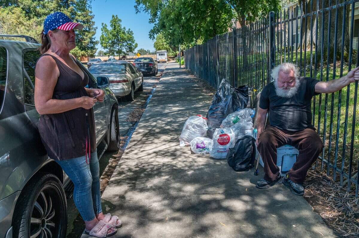 Jami Arbuckle, 52, left, sobs as she explains that her friend Donald Lowery, 73, right, is homeless and in bad health and was kicked out of a motel after he returned from the hospital recently in Sacramento. He is one of about 250 people that have been kicked out of the three Project Roomkey motels in Sacramento. “I can handle it a lot better than he can. He isn’t as strong as he used to be,” she said.