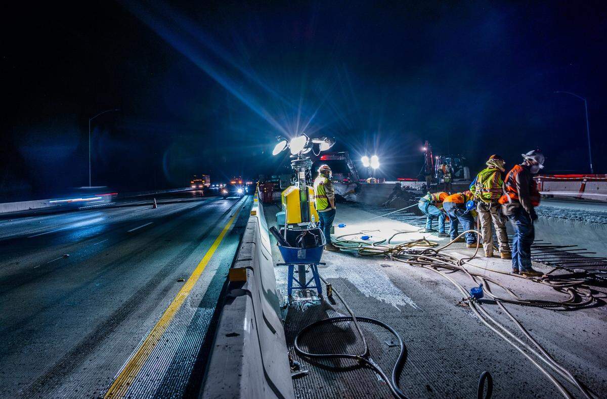 Traffic moves along Highway 50 on Thursday night, May 20, 2021, as workers demolish the inner edges of the freeway’s W-X section. Caltrans has shifted traffic lanes in both directions to the right and reduced widths from 12 feet to 11 feet to make room along the median for crews to cut off three-foot slices of the inside edge before the gap between the bridges is closed for new lanes.