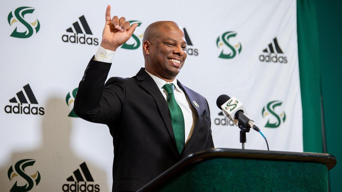 Sacramento State new men’s basketball coach David Patrick signals “stingers up” during his press conference with athletic director Mark Orr at Sacramento State University in Sacramento, Tuesday, April 12, 2022.