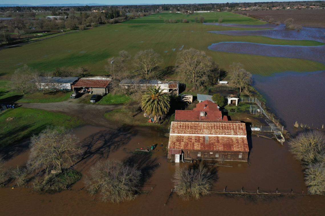 A farm on Freeman Road south of Elk Grove is surrounded by flood waters on Sunday, Jan. 1, 2023, following flooding from heavy rains on New Year’s Eve. Two levees breached in the area, prompting calls for residents to seek higher ground and closing Highway 99.