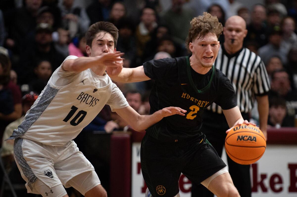 The Monterey Dores’ Ryan Roth (2) evades Union Mine’s Hayden Otte (10) in the first half of Division lV Northern California boys basketball championship at Union Mine High School in El Dorado on Tuesday.