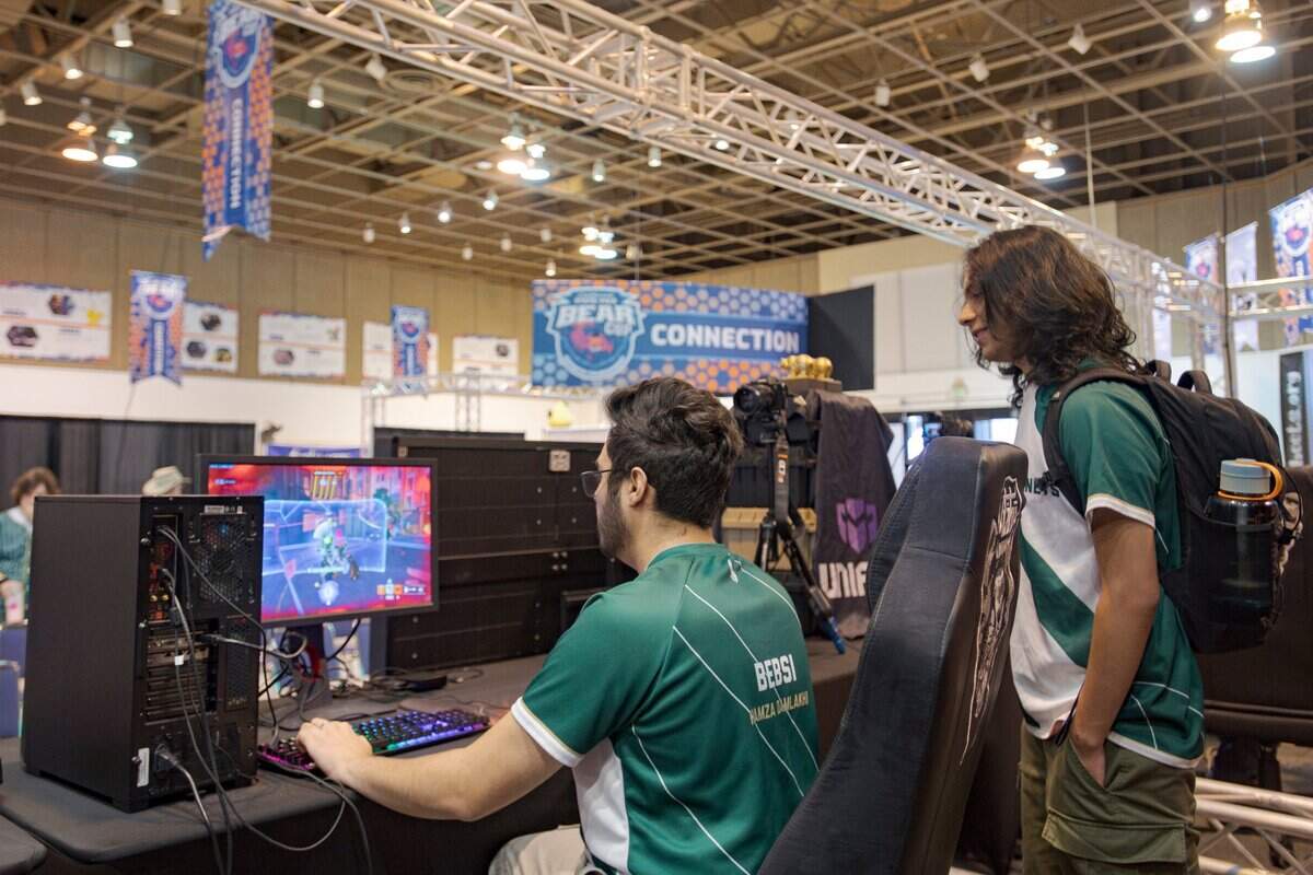 Sacramento State esports player Hamza Damlakhi, a member of the green team, plays Overwatch while he warms up before the Bear Cup tournament at the California State Fair on Thursday.
