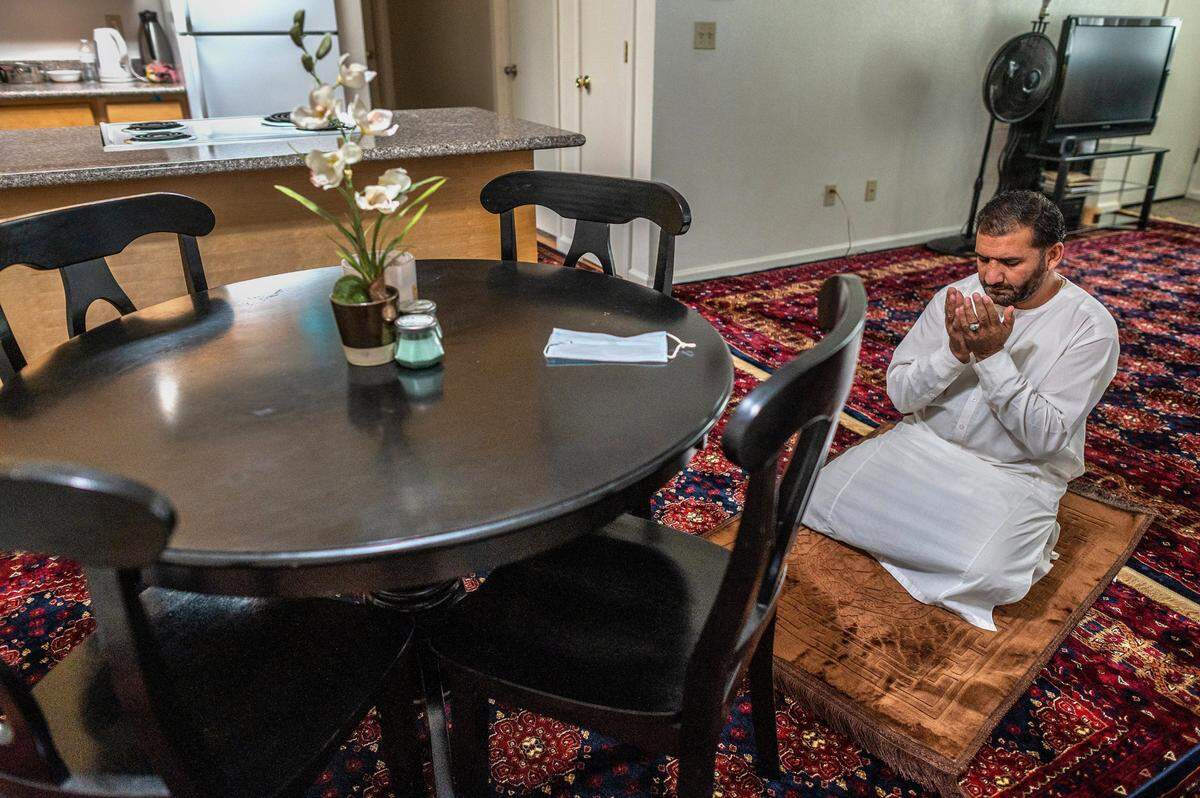 Abdul prays in his new apartment. He said, through son Rashed, that he was praying for a good life in America for his family, and peace for those who remained in Afghanistan. “No bombs, no fighting,î he said.