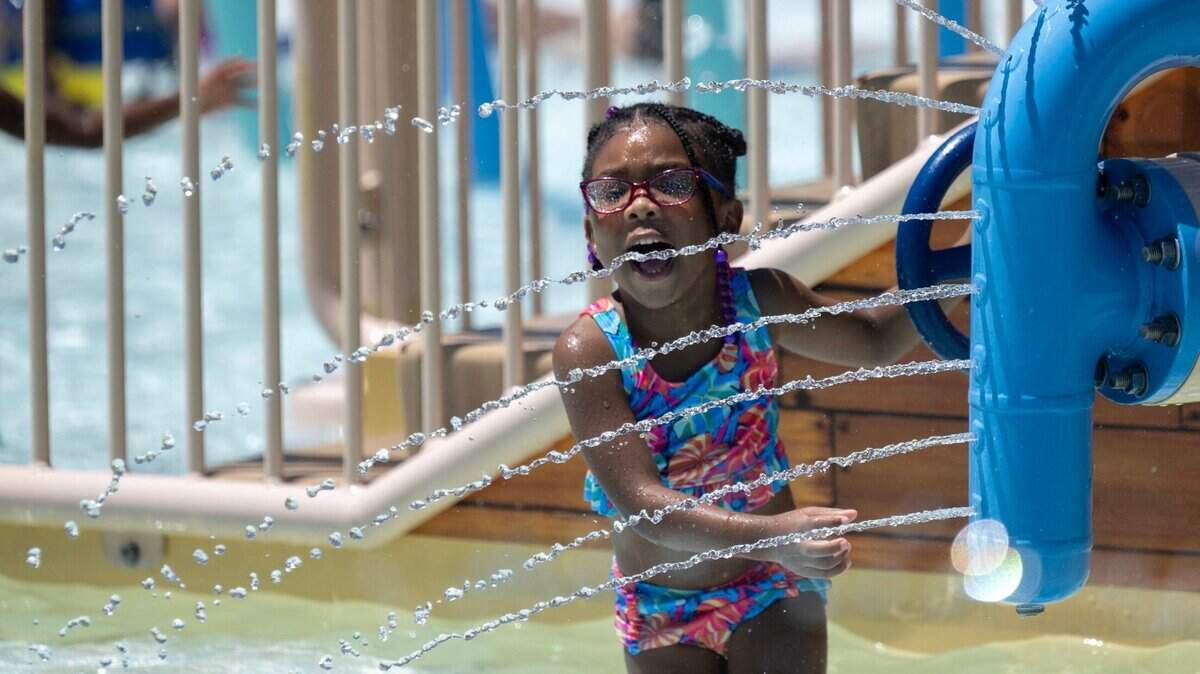 Zalaeyah Kirk, 3, of Citrus Heights plays with apparatus at North Natomas Aquatic Complex as temperatures reach 103 degrees on Monday, July 1, 2024 in Sacramento. Her father Xzavion Kirk says she cry when they have to leave the pool and begs to stay.