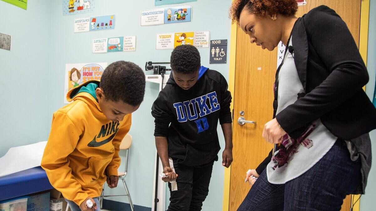LaTisha McCoy-Best, a Wake County school nurse assigned to Dillard Drive Elementary School, right, reviews proper Epipen procedures with fourth-graders Ayham Mahmoud, left, and Micah King at the school Monday, April 9, 2018. A state report focusing on the need for more school nurses was presented to lawmakers Monday.
