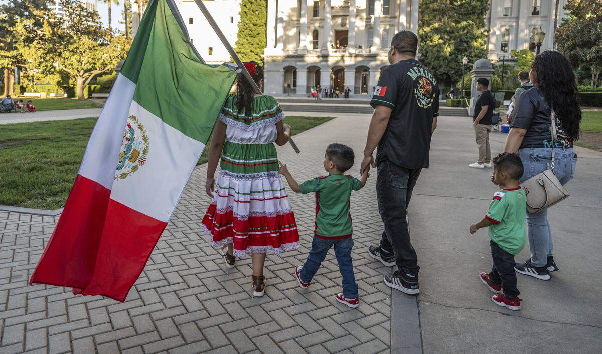 The Landeros family of Dixon arrives at Mexican Independence Day celebration at the state Capitol on Monday. The event, which can normally count on attendance in the thousands, drew a few hundred people this year amid the federal crackdown on immigration. 
