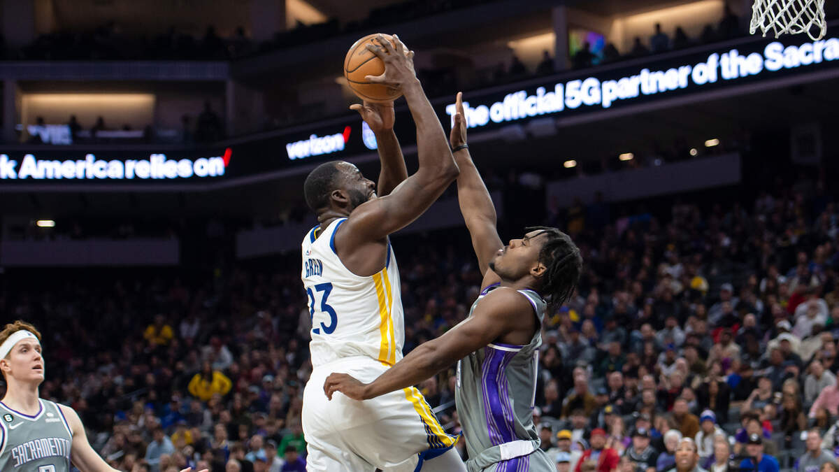 Golden State Warriors forward Draymond Green (23) attempts a shot over Sacramento Kings guard Davion Mitchell (15) during the fourth quarter in the NBA basketball game Sunday, Nov. 13, 2022, at Golden 1 Center in Sacramento. The Kings won 122-115.