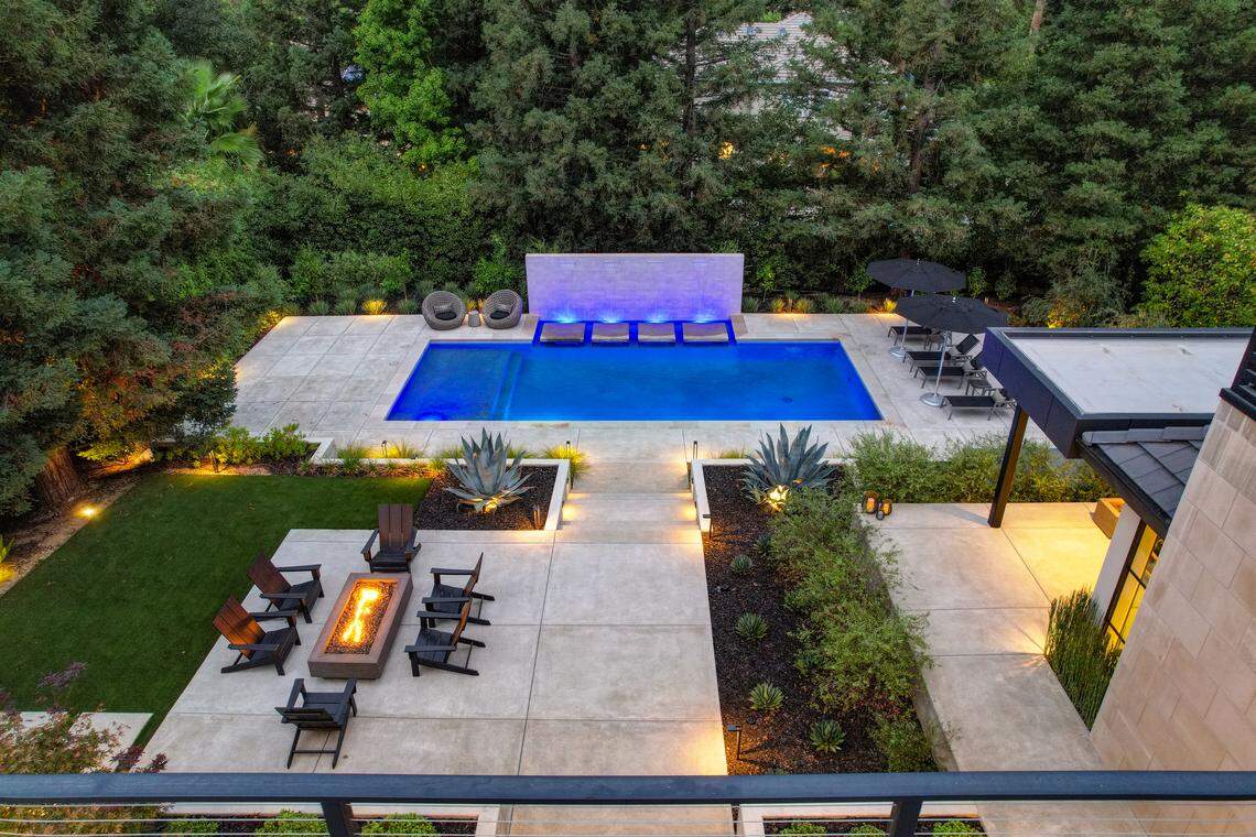 The terraced backyard is highlighted by the wall of fountains that are part of the pool.
