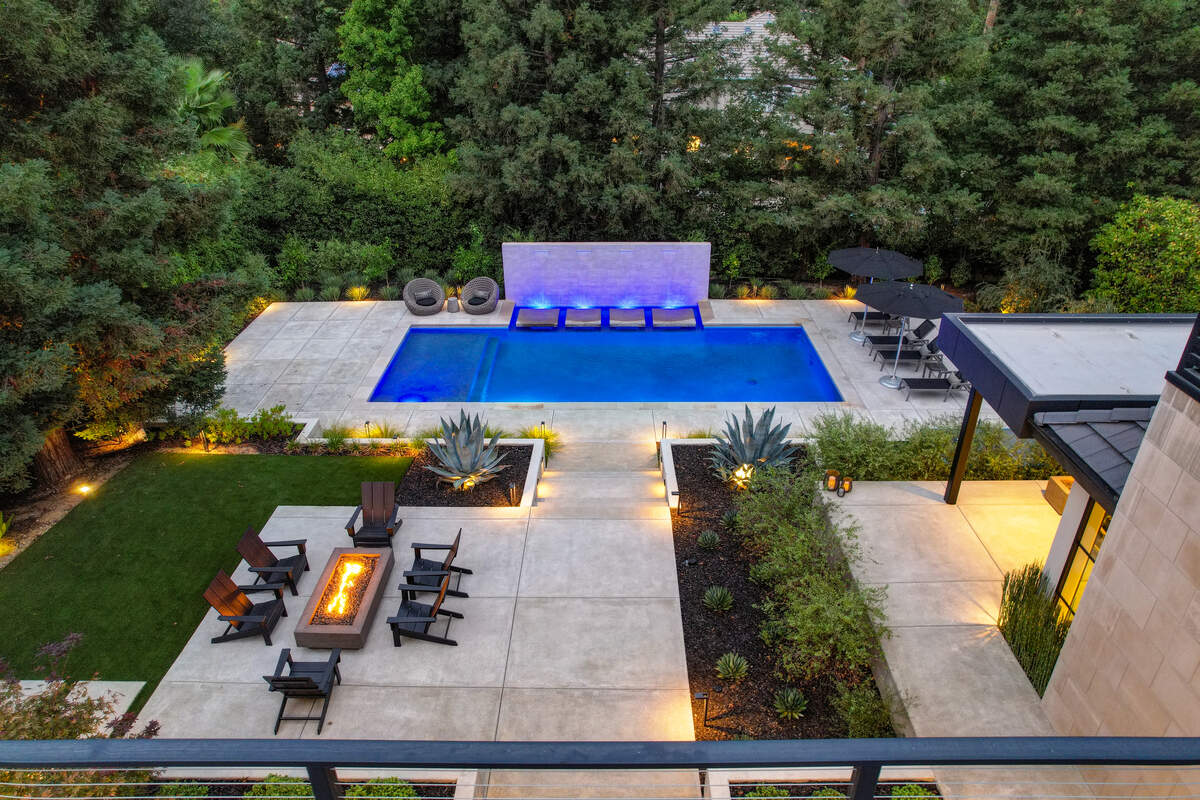 The terraced backyard is highlighted by the wall of fountains that are part of the pool.