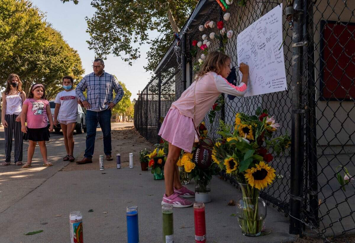 5. Jaylen Betschart’s cousin writes a message at a memorial for him at the East Sacramento Little League fields as other family members watch on Monday, Oct. 5, 2020. The 17-year-old was fatally shot Saturday while driving on Jackson Road. Betschart was an athlete at Sacramento High School and a former little league baseball player.