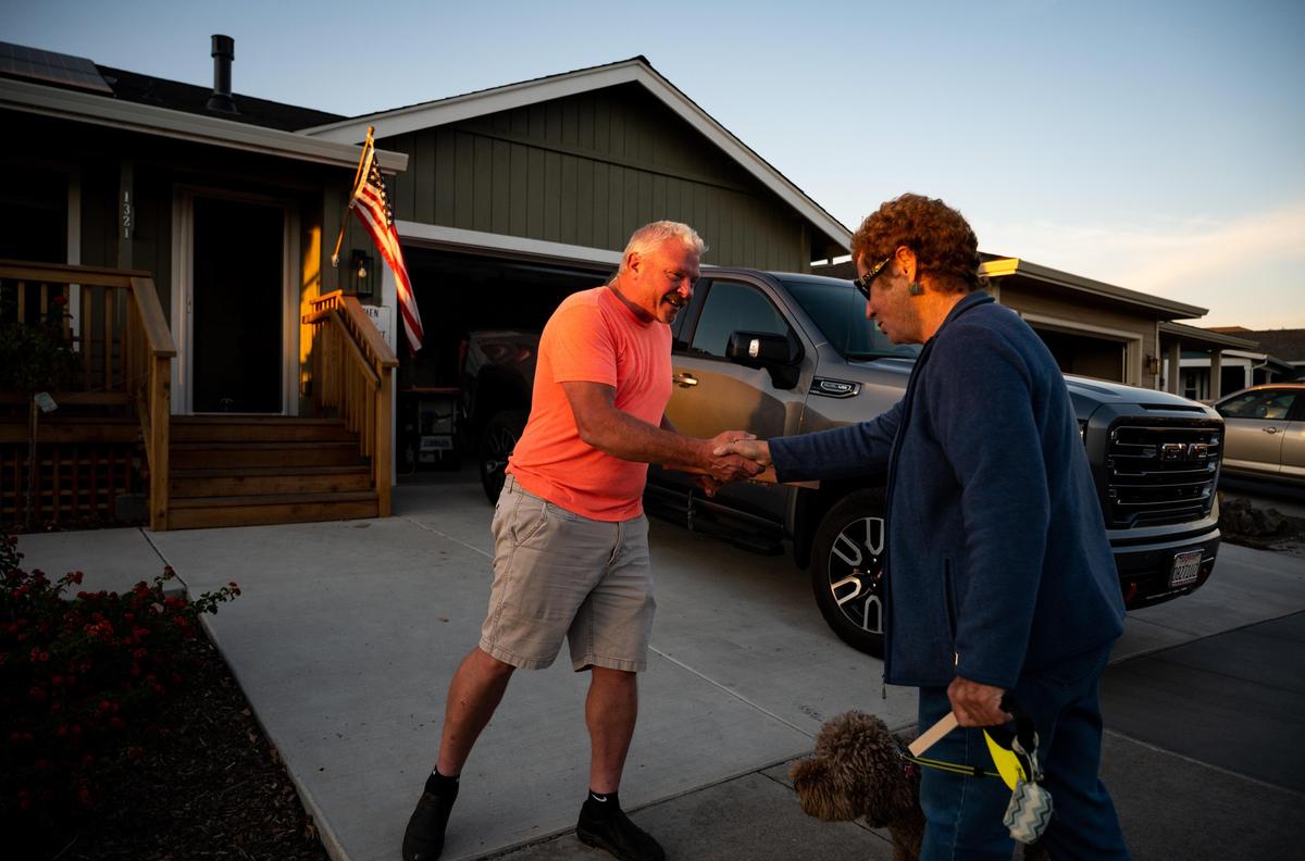 Mark Pedersen stands in front of his rebuilt Dogwood Drive home Nov. 5, 2019, and greets Coffey Park neighbor Margaret Ahern, who recently returned to the Santa Rosa neighborhood with her dog, Bella. “I live on Piñon,” Ahern said, “I just moved (back) a month ago, I still have boxes to unpack.” She added that she rebuilt on the same lot where she lost her home in the 2017 Tubbs Fire, which destroyed thousands of homes and led to five deaths in the area. “I moved back end of May, beginning of June of this year,” Pedersen said. “Yes, it’s expensive to live here for sure, but this is home,” he added, “I’ve lived in Santa Rosa all my life, I was born and raised here.”
