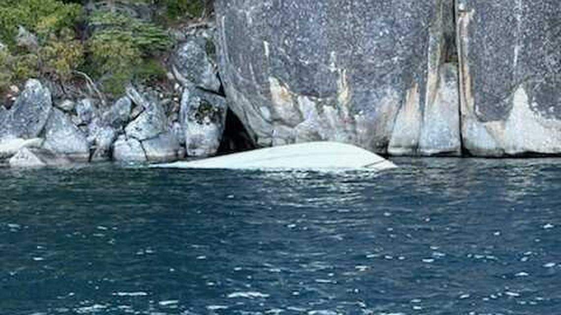 An overturned 27-foot Chris-Craft floats partially submerged near D.L. Bliss State Park on Lake Tahoe on Saturday. The boat capsized in high winds and rough swells, leaving six people dead and two others missing, according to the U.S. Coast Guard.