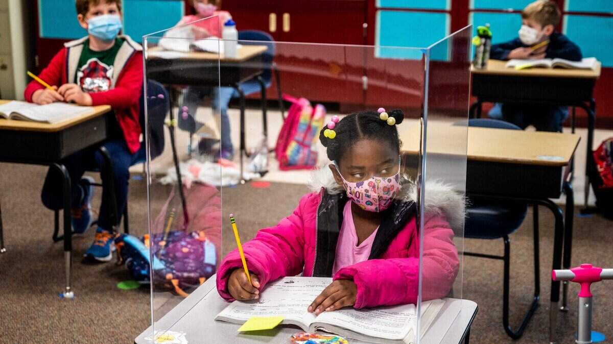 First grader Sophia Frazier does her schoolwork behind a plastic divider – only the students near the teacher’s desk seemed to have them – during class at Two Rivers Elementary School on Monday, March 8, 2021. It was the first day in class at the school for third through fifth graders, but the first graders returned last week.