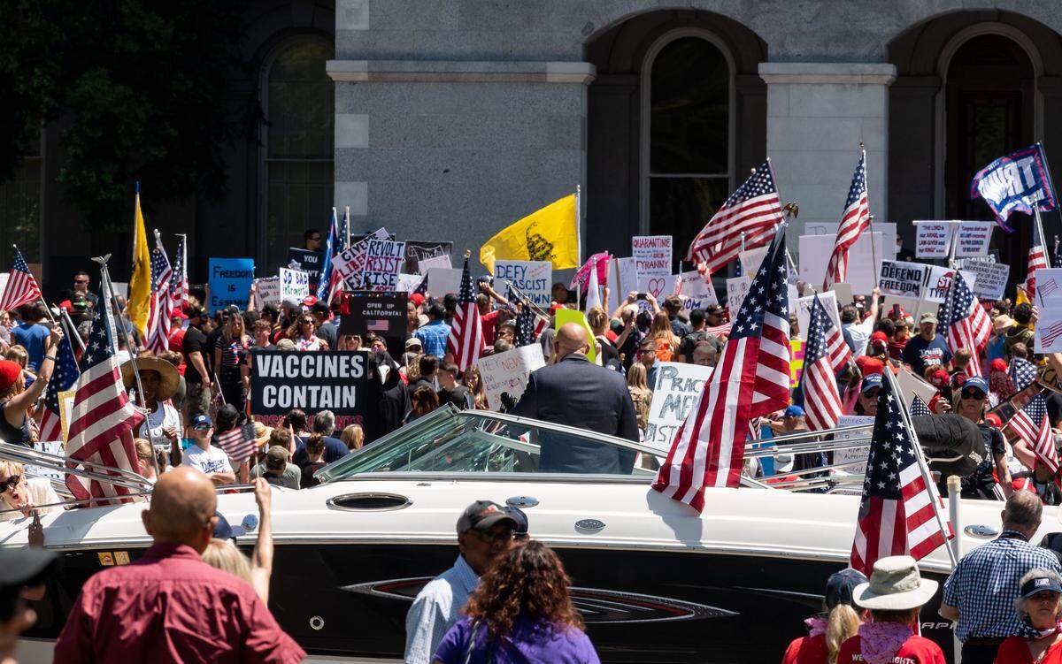 A man addresses demonstrators gathered on the Capitol steps from a boat towed by a vehicle on 10th Street during a protest against Gov. Gavins Newsom’s stay-at-home order Friday, May 1, 2020, in Sacramento.