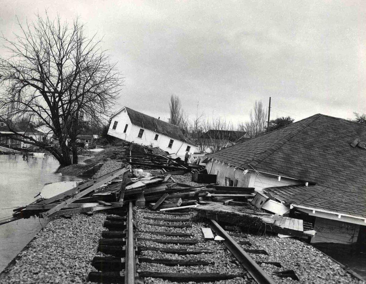 A house tilts at a crazy angle while another is buckled against a railroad embankment as flood waters recede in Yuba City on Sunday, Dec. 25, 1955. The wreckage is indicative of the havoc left by the inundation of a large section of Sutter County.