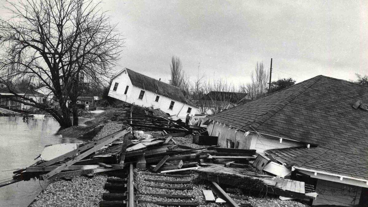 A house tilts at a crazy angle while another is buckled against a railroad embankment as flood waters recede in Yuba City on Sunday, Dec. 25, 1955. The wreckage is indicative of the havoc left by the weekend inundation of a large section of Sutter County.