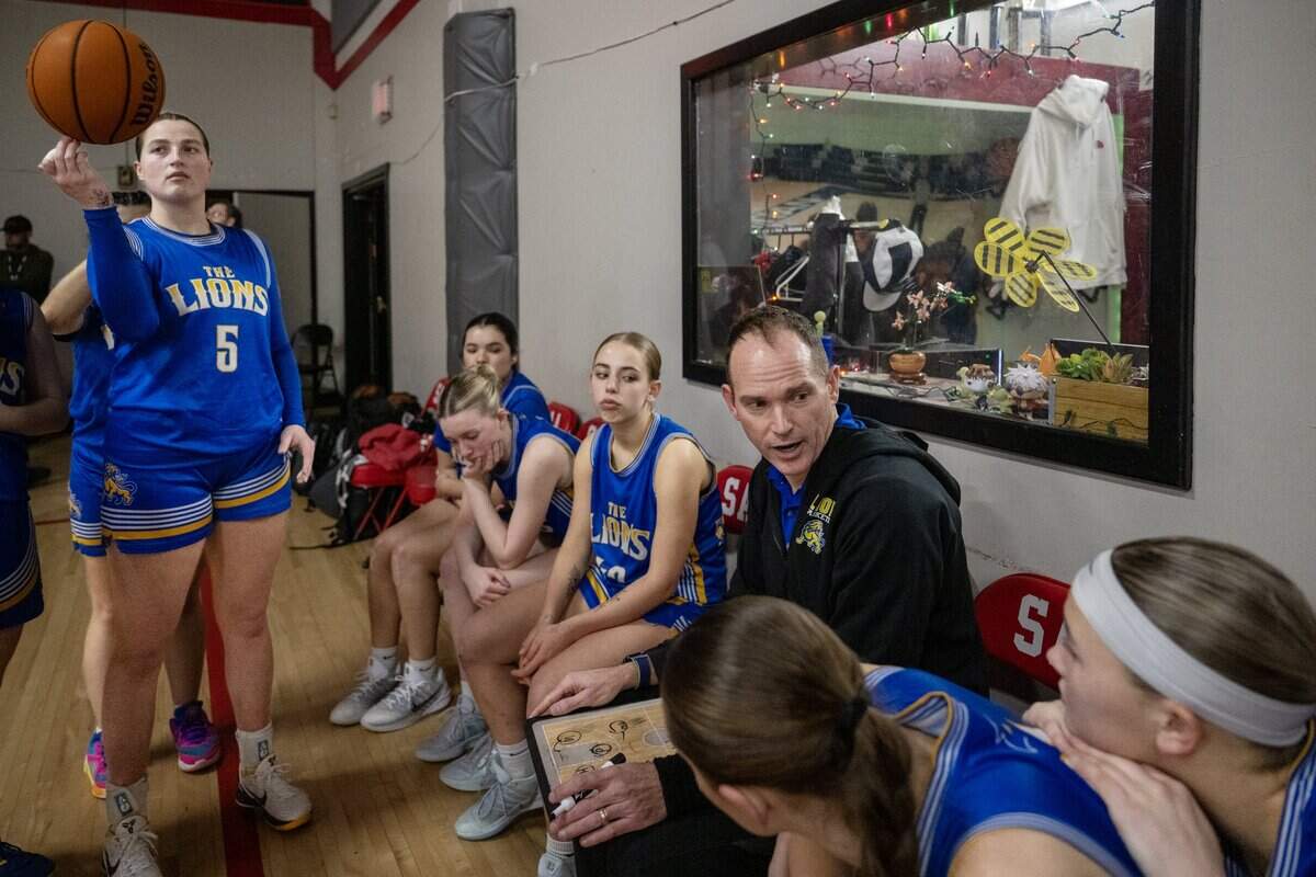 Faith Christian Lions coach Geoff Harris talks to his team during halftime of their game against the Sacramento Adventist Capitals on Tuesday in Carmichael, as his daughter Lauren Harris (5) spins a basketball.