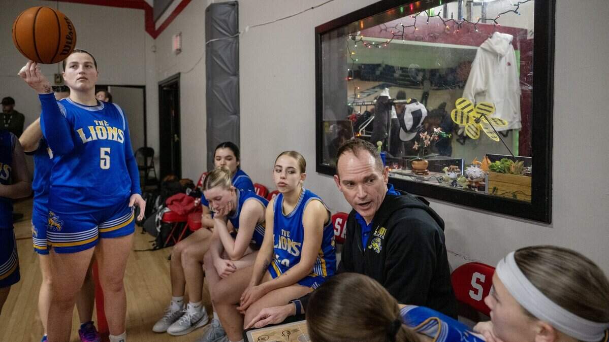 Faith Christian Lions coach Geoff Harris talks to his team during halftime of their game against the Sacramento Adventist Capitals on Tuesday, Jan. 27, 2026, in Carmichael, as his daughter Lauren Harris (5) spins a basketball.
