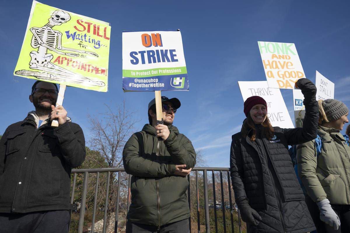 Striking medical workers wave signs outside Kaiser Permanente’s Roseville Medical Center in Roseville on Monday, Jan. 26, 2026.