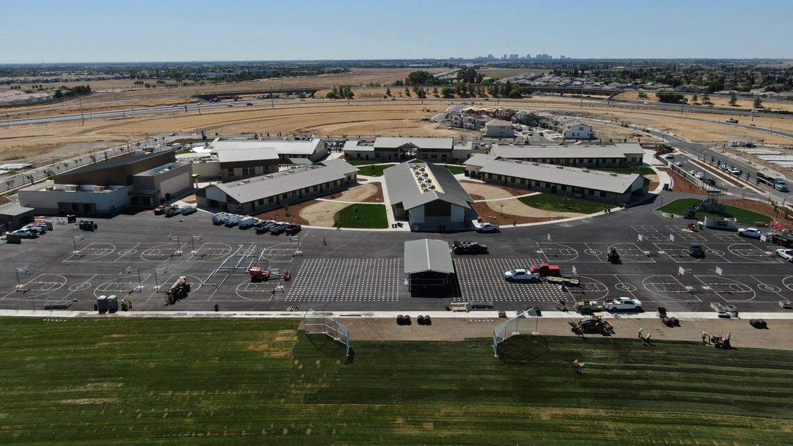 Workers install a grass field at Northlake TK-8 in North Natomas on Monday, the day before the school’s first day. 