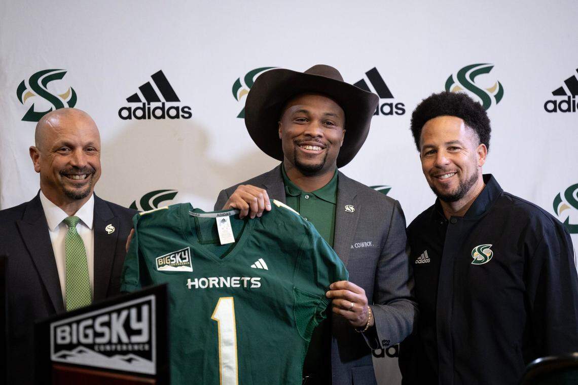 New Sacramento State head football coach Brennan Marion holds a Hornets jersey with Athletic Director Mark Orr and university President Luke Wood after being introduced as the school’s 13th head football coach on Wednesday, Jan. 8, 2025.