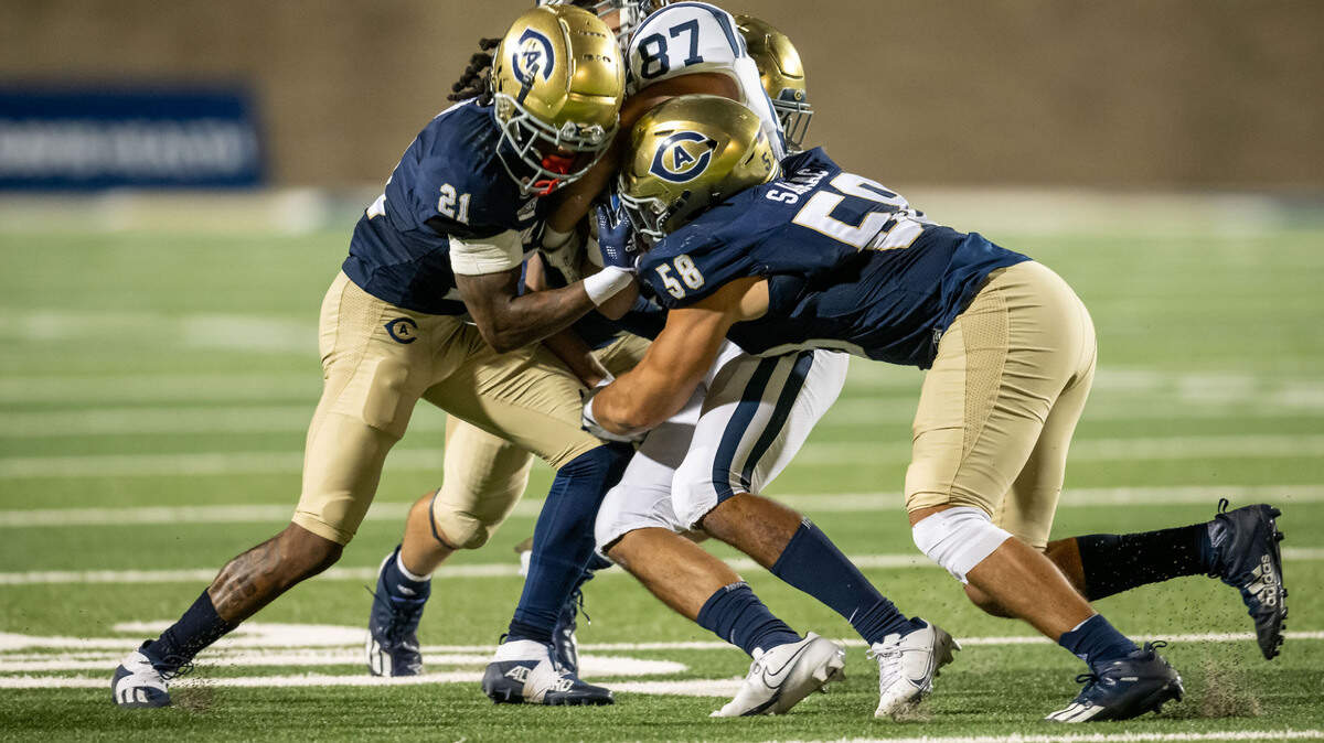 San Diego Toreros wide receiver Vance Jefferson (87) is sandwiched by UC Davis Aggies defensive back Devon King (21), left, linebacker Luka Sarac (58), right, and defensive back Rex Connors (4) on Sept. 17 at UC Davis Health Stadium.