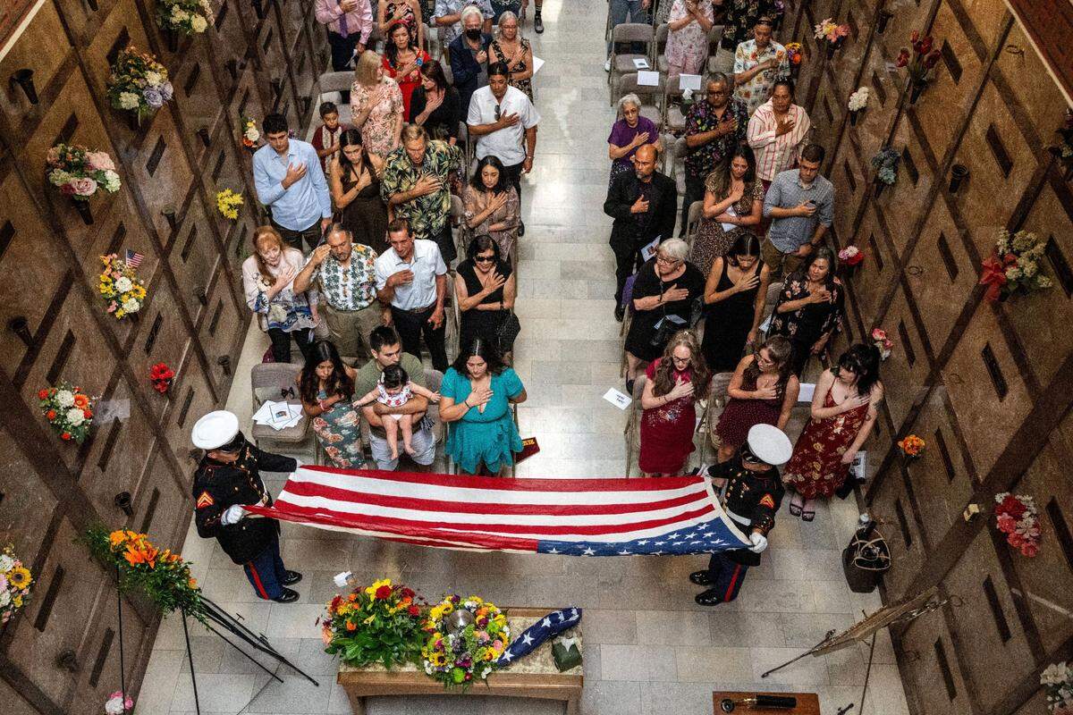 A Marine honor guard prepares to fold an American flag in front of the family and friends of José Luis Silva as they attend his funeral at East Lawn Cemetery in Sacramento.