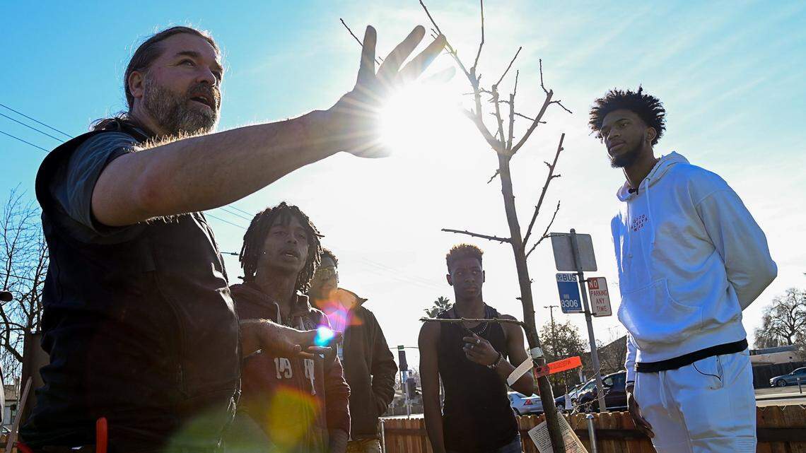 Kings rookie Marvin Bagley III, right, listens to Dominic Allamano of Green Tech Education explain the process of planting trees.